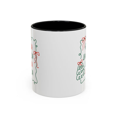 White ceramic Fa La La Christmas coffee mug with minimalist green and red holiday design and black interior, microwave and dishwasher safe.