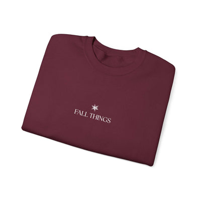 folded maroon Fall Things sweatshirt with minimalist autumn design and cozy crewneck collar