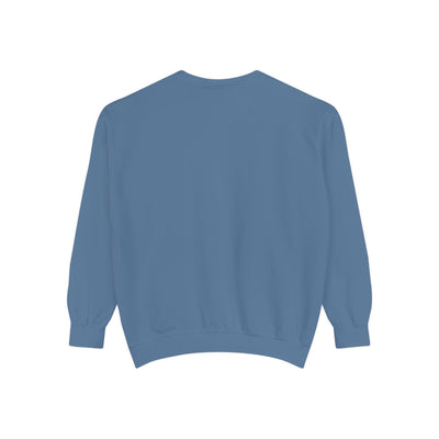 Cozy unisex garment-dyed sweatshirt in blue with minimalist embroidery, ribbed collar, cuffs, and hem.