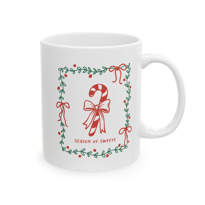 White ceramic mug with green border and candy cane design saying Season of Sweets in red text