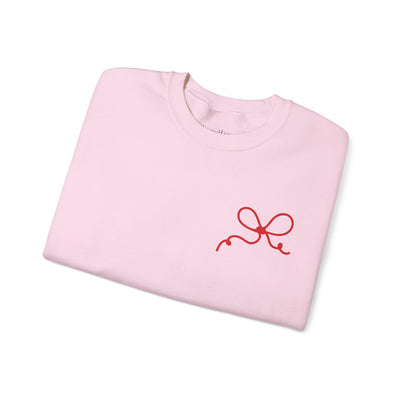 Folded pink Coquette Bow Crewneck Sweatshirt with small red bow design on front