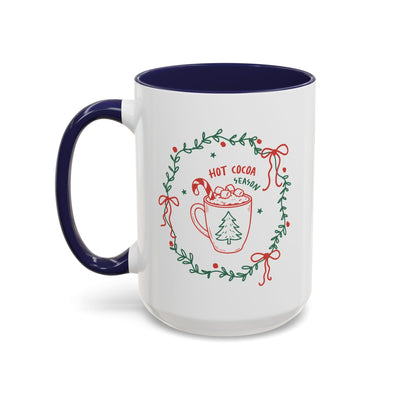 White ceramic mug with red and green hot cocoa season design and navy interior and handle