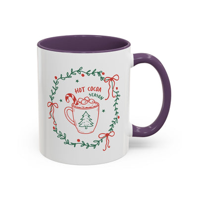 white ceramic mug with purple interior and handle featuring festive hot cocoa season design