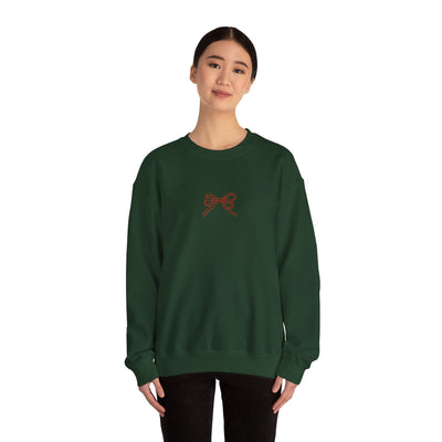 Woman wearing green Holiday Bow Crewneck Sweatshirt with red bow design on front, festive holiday apparel