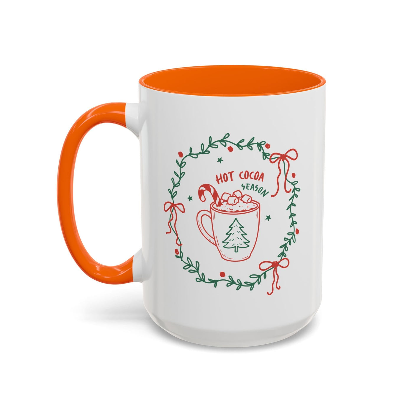 White ceramic mug with orange interior and handle, festive hot cocoa season design with greenery wreath and holiday elements