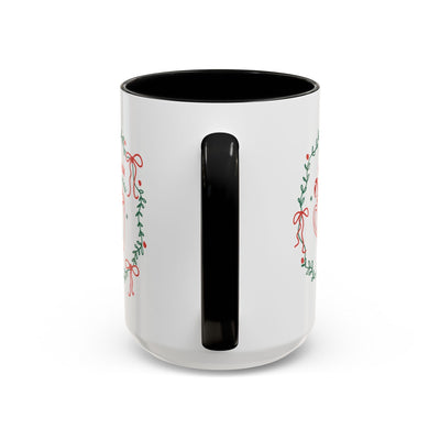 White ceramic mug with black handle and interior, featuring festive greenery design