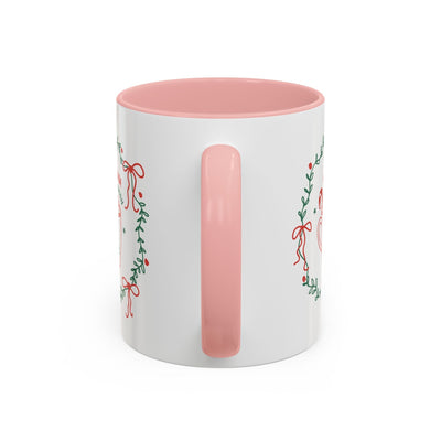 White ceramic mug with pink interior and handle featuring festive greenery and red bow design