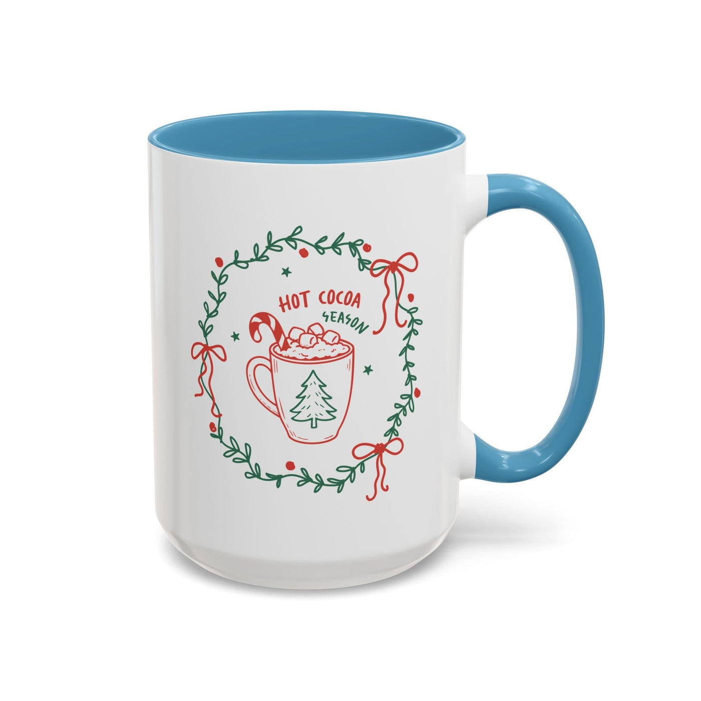 White ceramic mug with blue handle and interior, festive hot cocoa season design with greenery wreath and holiday illustrations