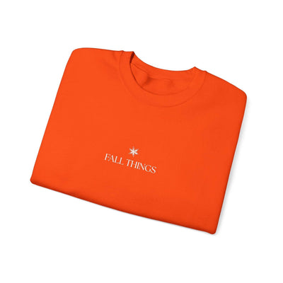 Folded orange Fall Things Sweatshirt with minimalist white text and star design on chest, soft cotton-polyester blend, cozy autumn crewneck for coffee lovers and homebodies