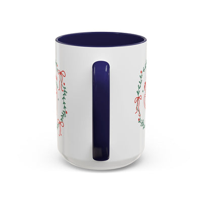 White ceramic mug with navy handle and interior, festive greenery and ribbon design, available in 11oz and 15oz sizes