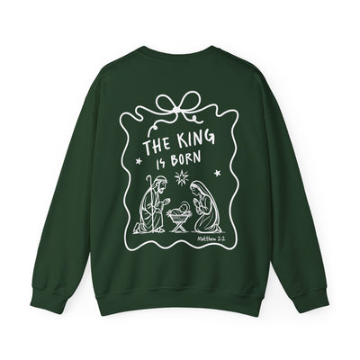 Dark green Coquette Bow Crewneck Sweatshirt with white "The King is Born" faith design and festive nativity illustration on back.