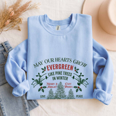 Light blue Christmas crewneck sweatshirt with festive evergreen pine tree design and holiday message, cozy holiday sweatshirt by Brew’d Up Designs
