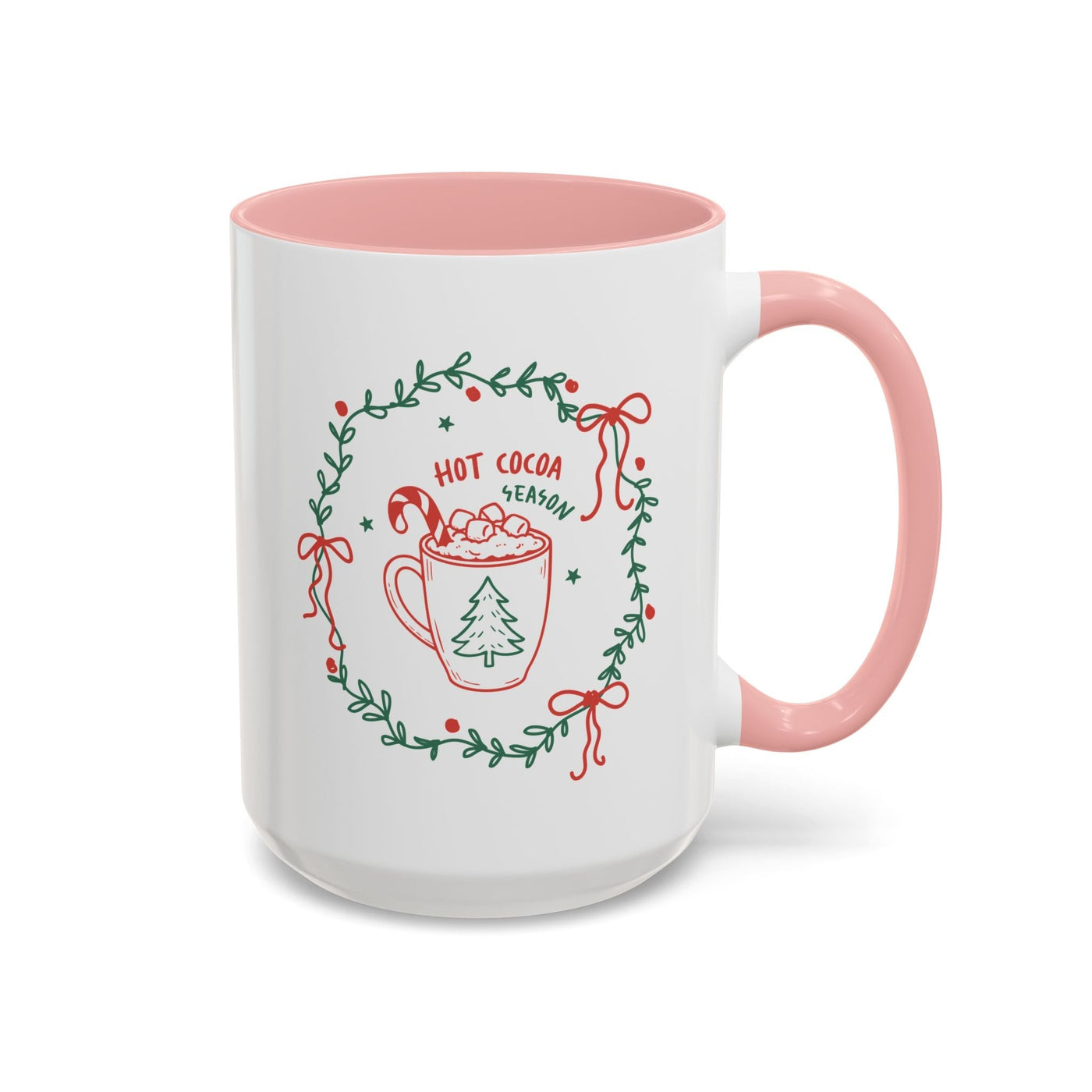 white ceramic mug with pink handle and interior featuring hot cocoa season wreath design