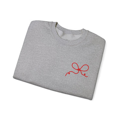 Folded gray crewneck sweatshirt with red coquette bow design on front pocket area