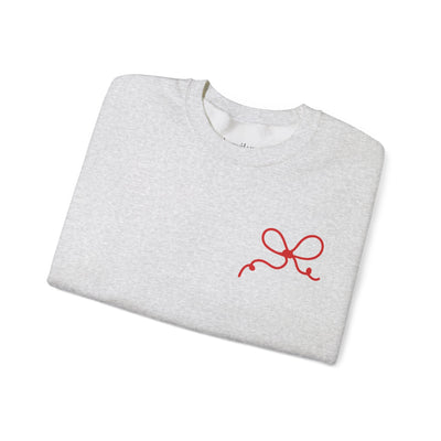 Folded grey Coquette Bow Crewneck Sweatshirt with small red bow design on front.
