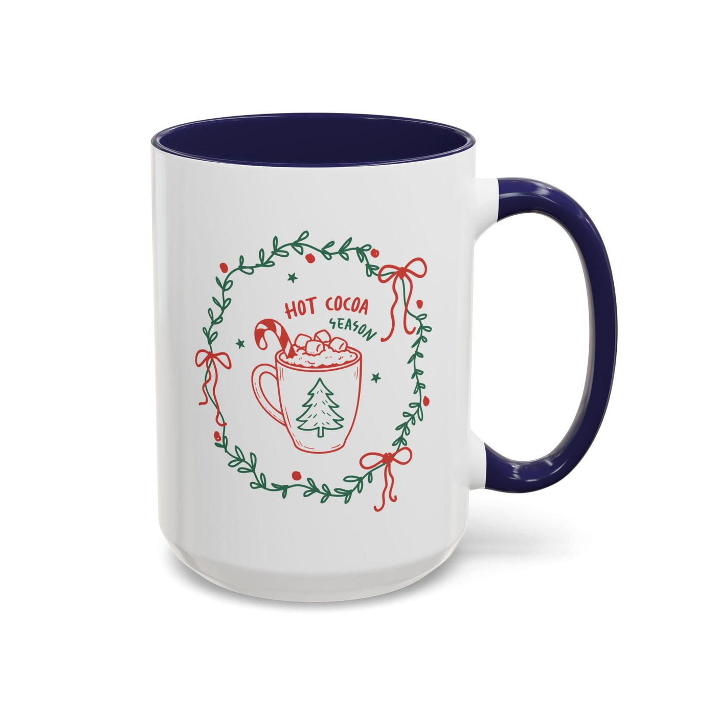 White ceramic mug with navy interior and handle, featuring festive "Hot Cocoa Season" design with greenery wreath and holiday motifs