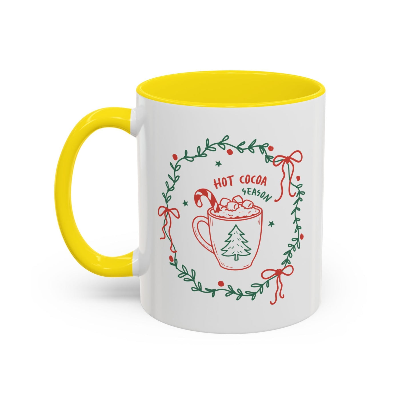 White ceramic mug with yellow handle and interior featuring festive hot cocoa season design with greenery wreath and red bows