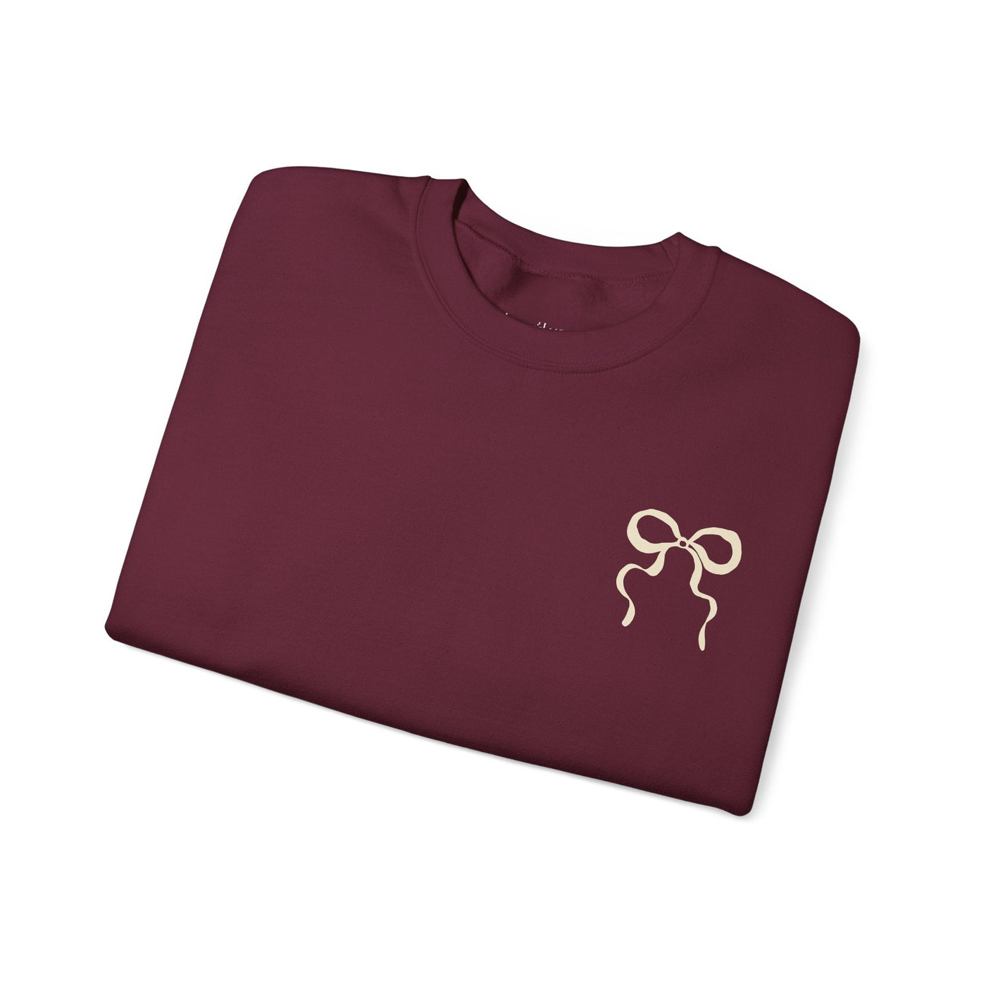 Folded maroon Coquette Christmas Faith crewneck sweatshirt with coquette bow design on front