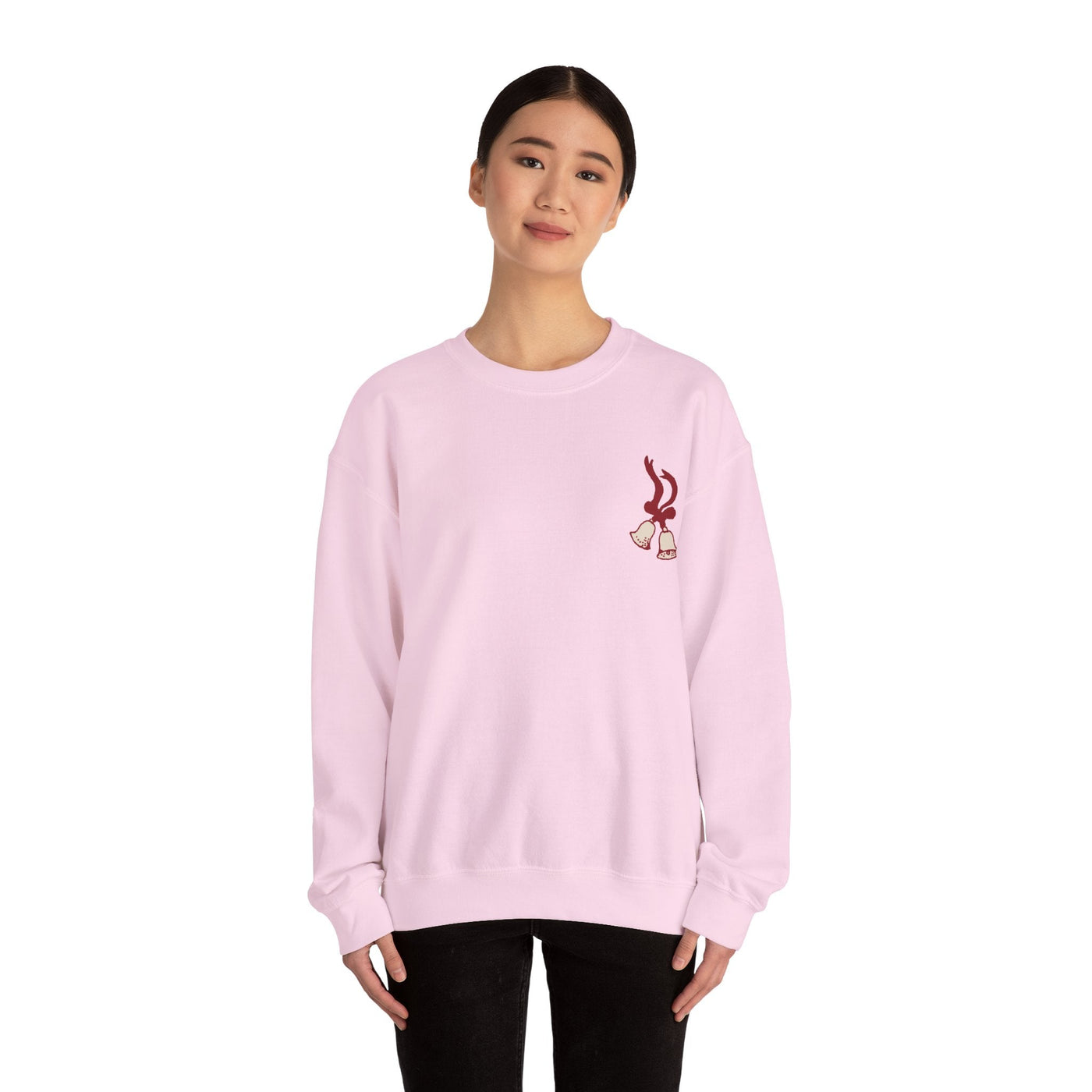 Woman wearing light pink vintage Merry Christmas crewneck sweatshirt with bell and Santa sleigh design by Brew’d Up Designs