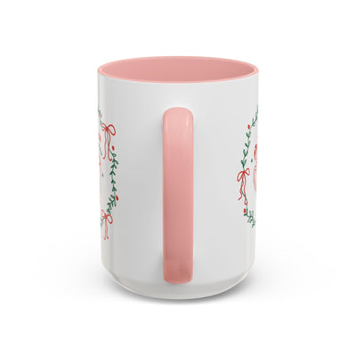 White ceramic mug with pink handle and interior featuring festive greenery and red ribbon design