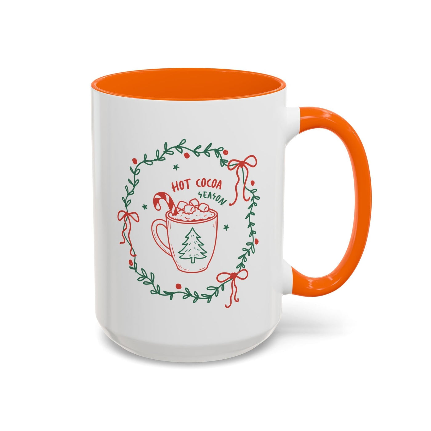 White ceramic mug with orange interior and handle, festive hot cocoa season design with greenery and holiday elements