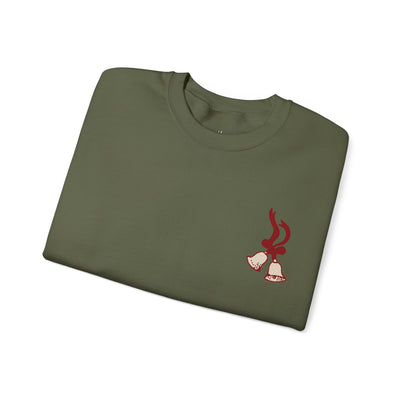 Folded vintage Merry Christmas crewneck sweatshirt with red bell and Santa sleigh design on olive green fabric