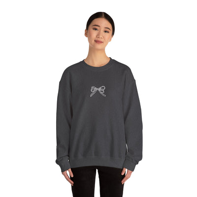 Woman wearing black Holiday Bow Crewneck Sweatshirt with bow design on front, festive cozy casual holiday top