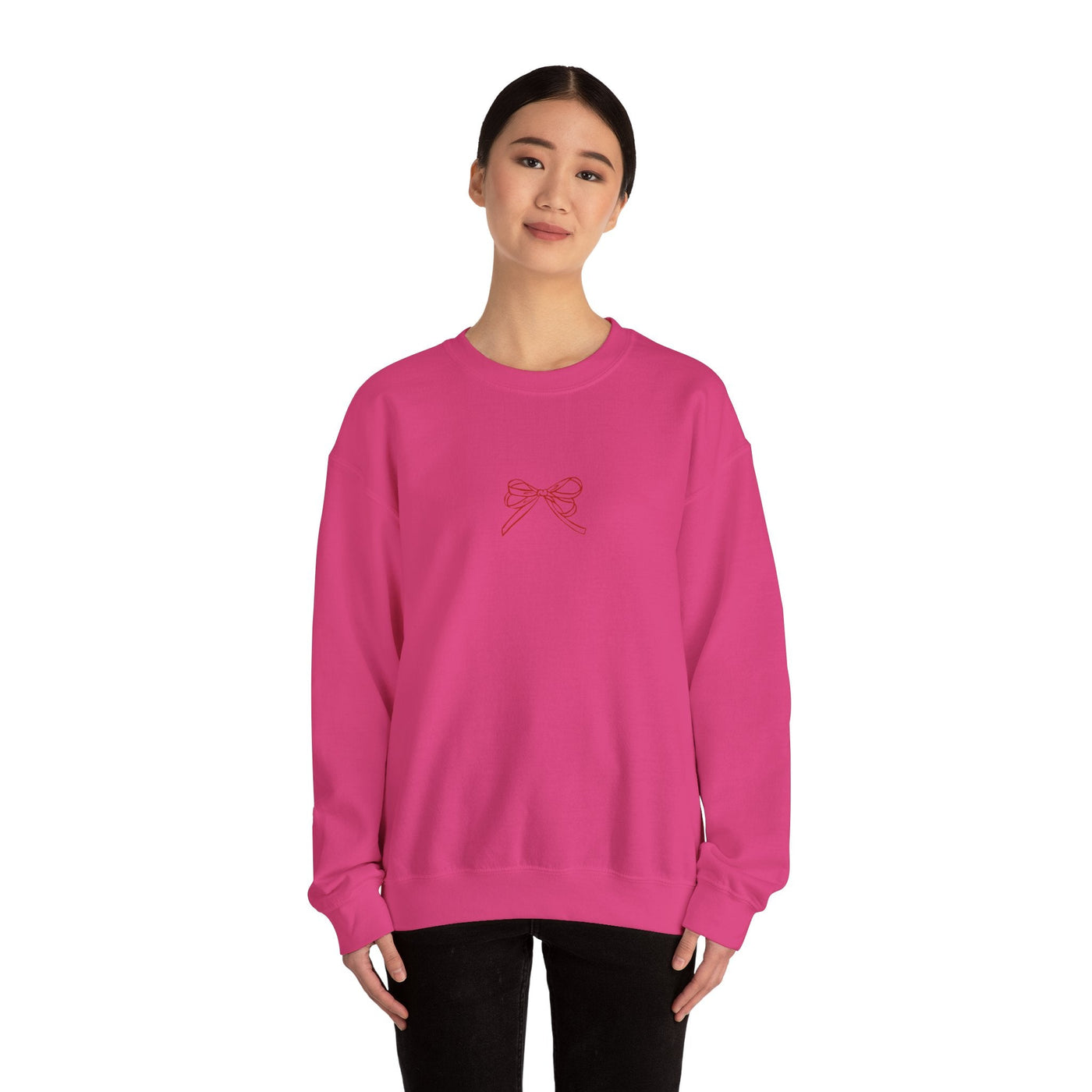 Woman wearing pink Holiday Bow Crewneck Sweatshirt with festive bow design on front