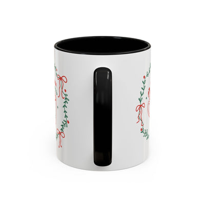 White ceramic mug with black handle and festive holiday wreath design, red interior, available in 11oz and 15oz sizes